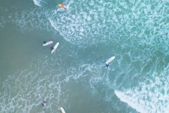 Aerial view of surfers at Summerlease beach, Bude, Cornwall, UK.