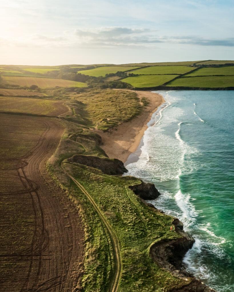 Aerial view of Harbour cove beach and sand dunes showing the sea and surrounding countryside, Padstow, Cornwall, UK.